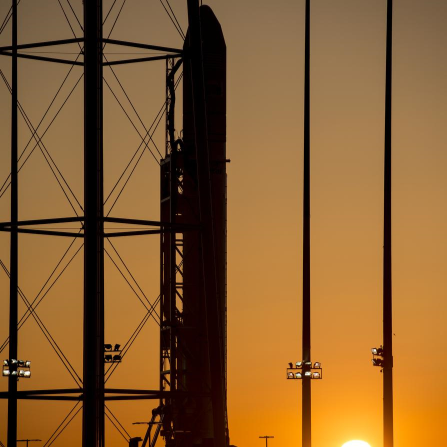 A shot of a rocket preparing to launch, with a sunrise in the background.