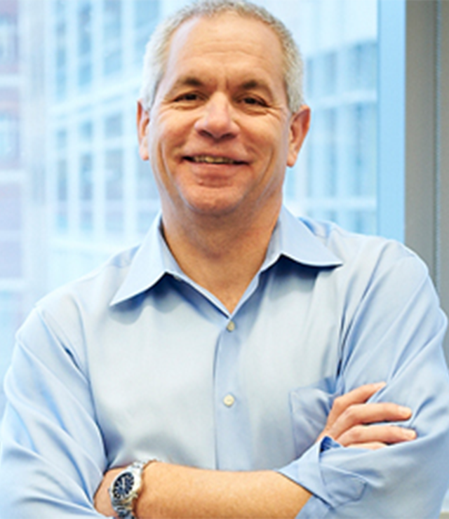 A man with his arms folded poses for the camera.