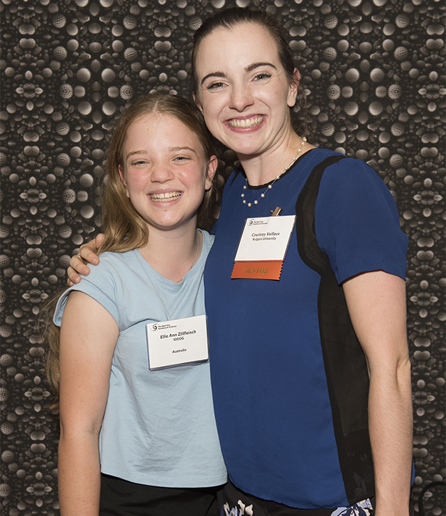 A young student smiles and poses with her mentor.