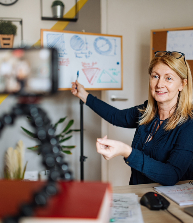 A woman video records herself giving a presentation.