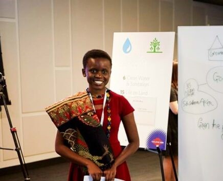 A woman poses with her research poster during an Academy event.