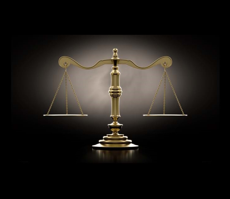 A dramtically lit gold justice scale backlit an a dark background - 3D render