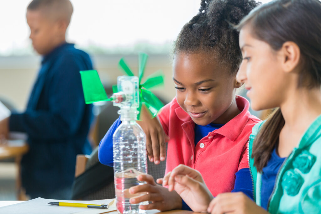 Two young students participate in a simple science experiment.