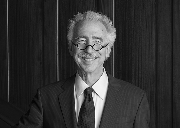 A black and white photo of a man smiling for the camera.