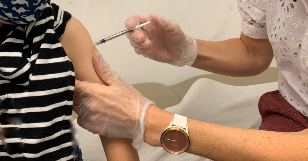 A healthcare professional gives a patient a vaccine shot.