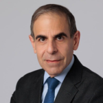 A man in a suit and tie poses for the camera.