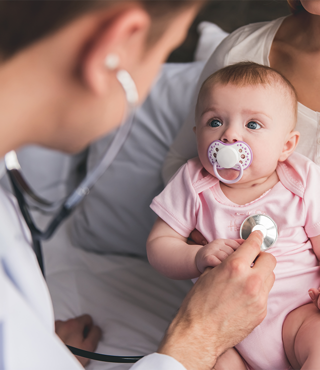 An infant being examined by a physician.