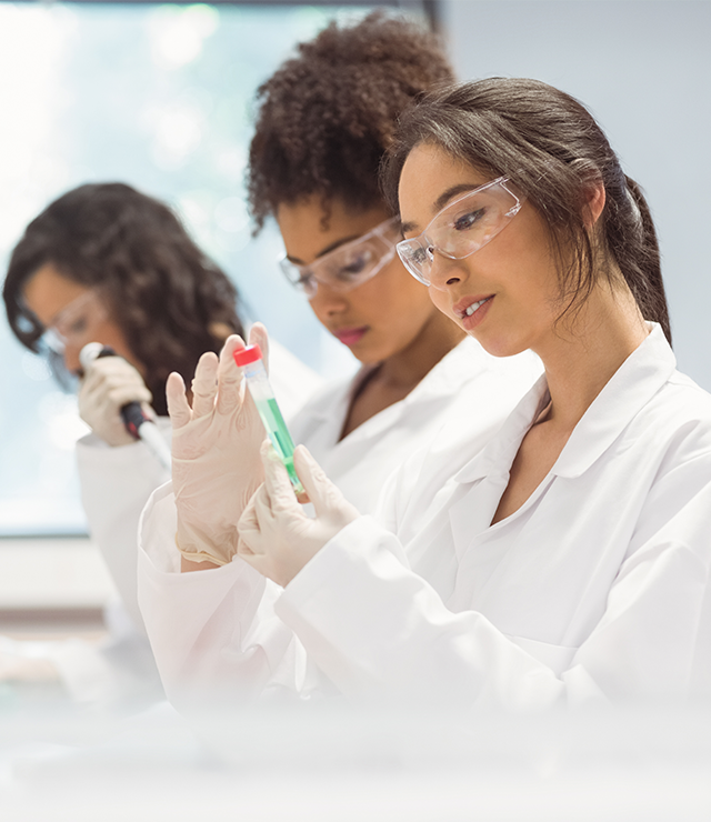A researcher examines a test tube inside a science lab.