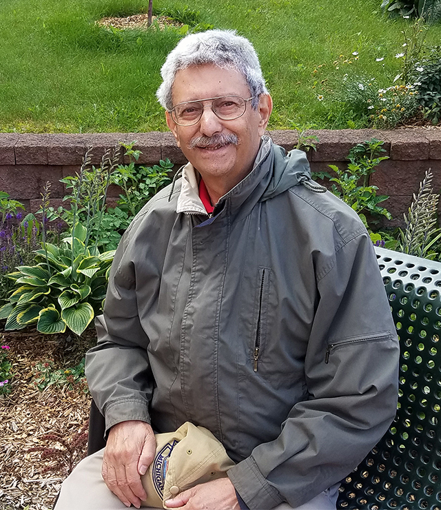 Herb Klitzner sits on a bench and poses outside for the camera.