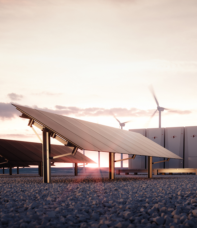 A photo with solar panels in the foreground, wind turbines in the middle ground, and the sun in the background.