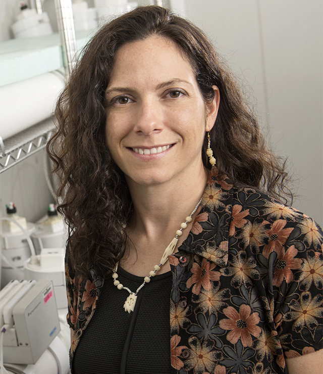 A professor smiles for the camera inside her research lab,