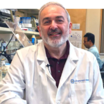 Dr. Adrian Krainer smiles for the camera inside his research lab.