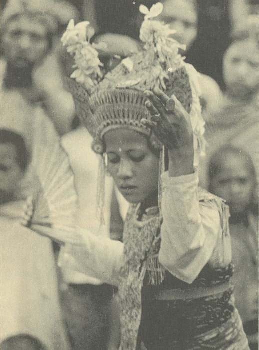 A black and white photo of a Balinese woman dancing.