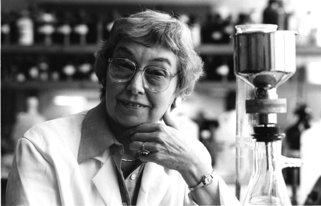 A woman poses for the camera inside a science lab.