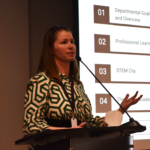 A woman gives a presentation during an Academy staff meeting.