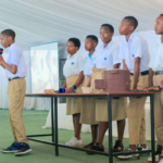 A group of students present their school project in front of onlookers.