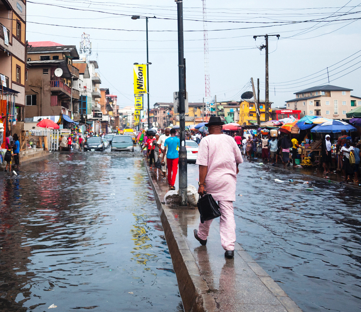 Pedestrians navigate a flooded city street.