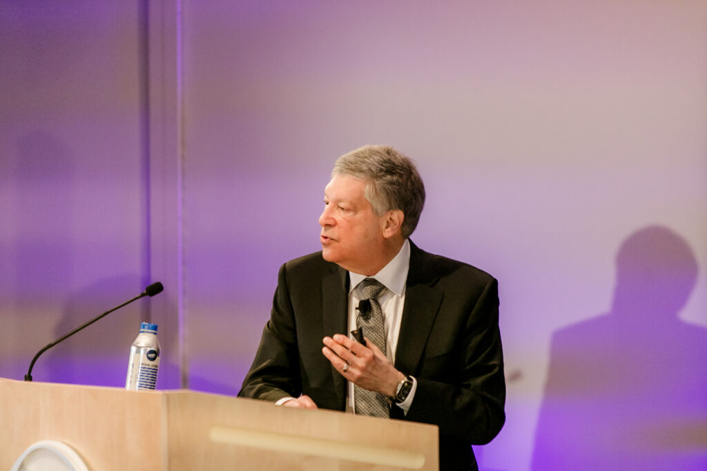 A man presents from the podium during the 2024 Innovators in Science Award symposium.