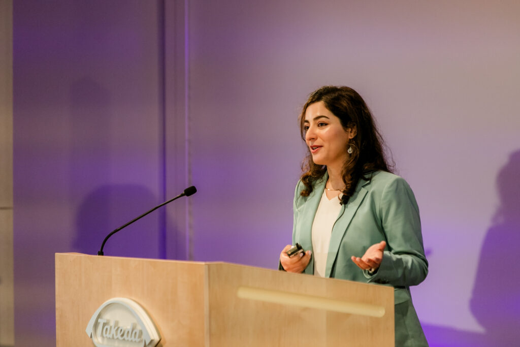 A woman presents from the podium during the 2024 Innovators in Science Award symposium.