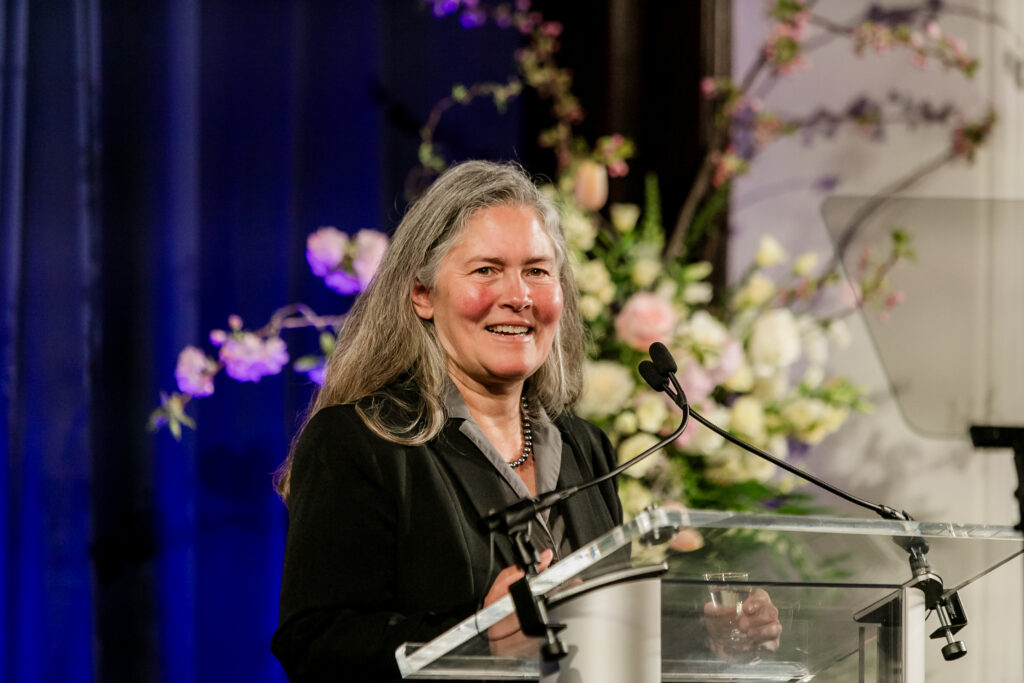 A woman presents from the podium during the 2024 Innovators in Science Award symposium.