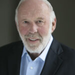 A headshot of a man wearing a suit.