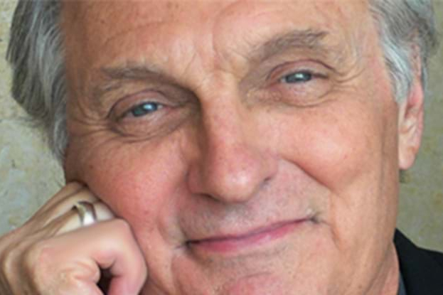 A headshot of a man smiling.