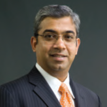 A man in a suit and tie poses for the camera.