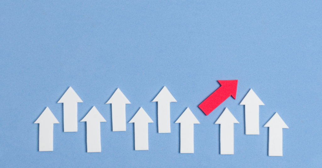 A group of white arrows pointing upwards, with one red arrow angled diagonally toward the top right