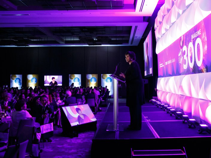 A woman stands at a podium and delivers an address.