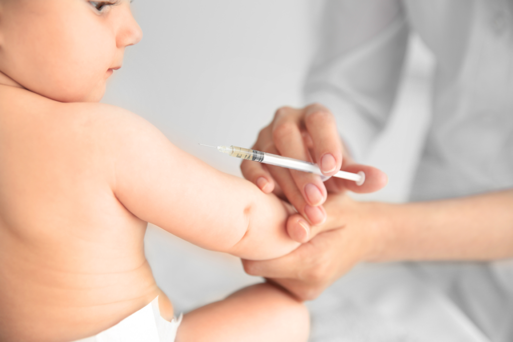 A stock photo of a medical professional giving a vaccine to an infant.