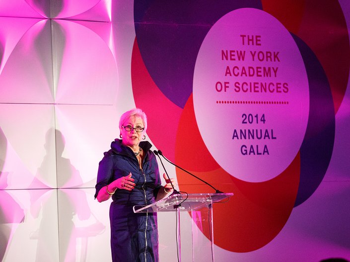 A woman stands at a podium and delivers an address.