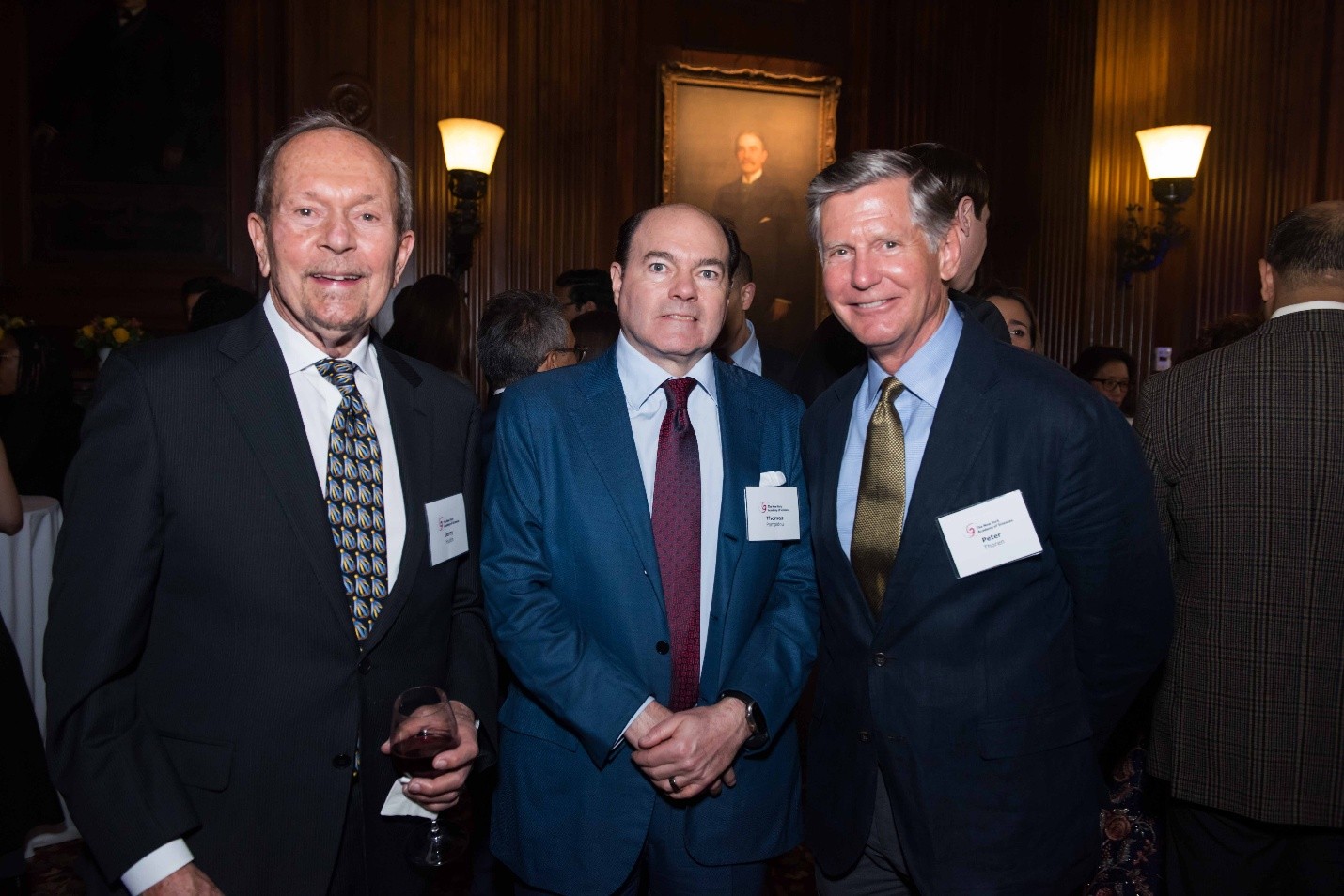 Three formally dressed men pose together.