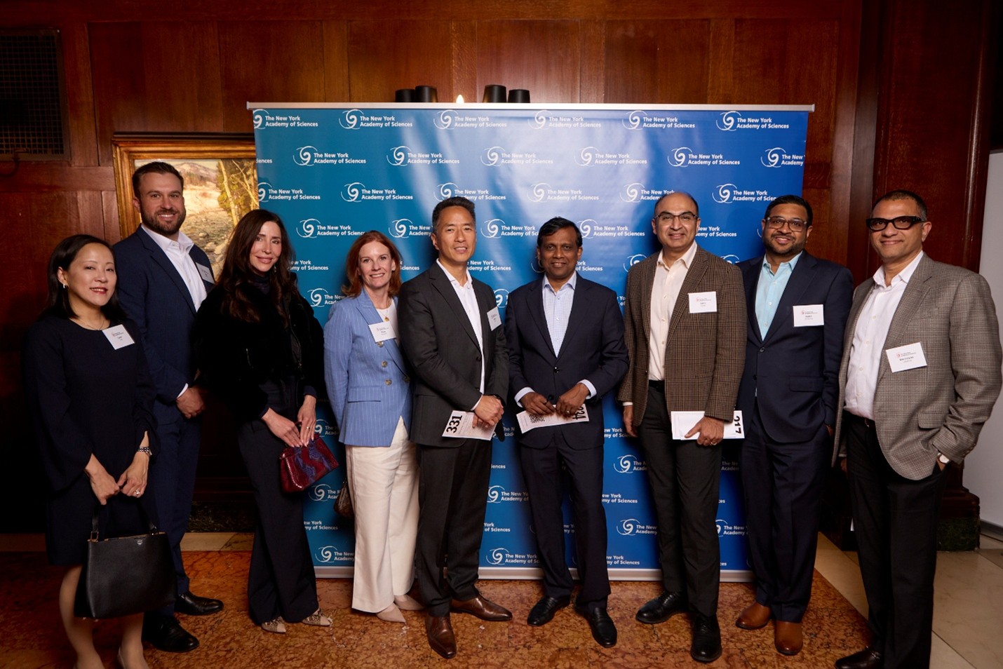 A large group of formally dressed people pose together.