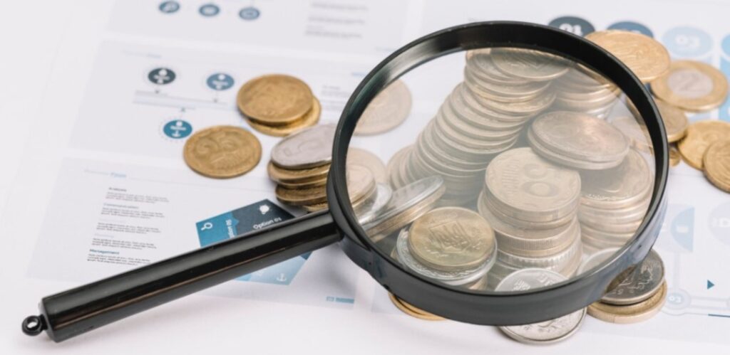 A magnifying glass focused on coins.