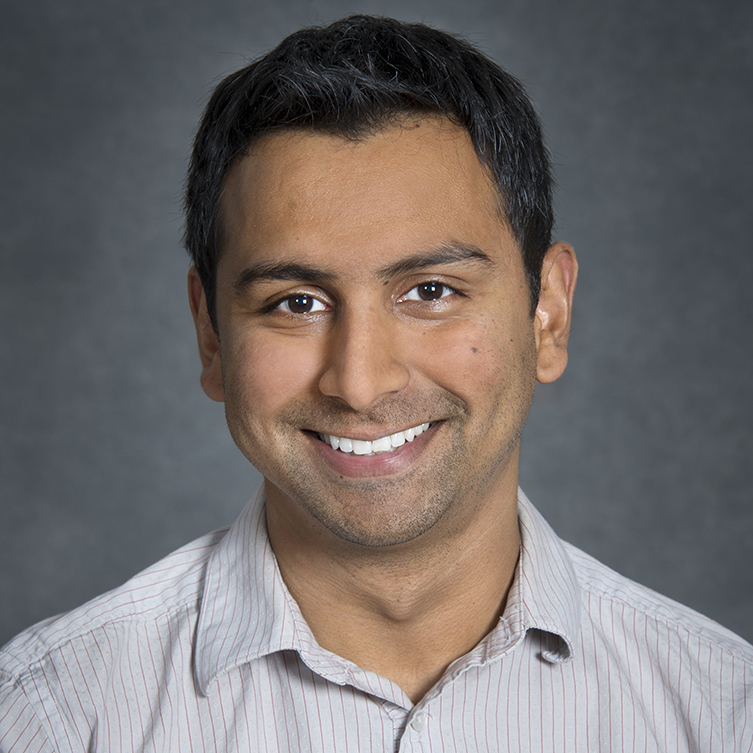 A formally dressed man smiles for the camera.