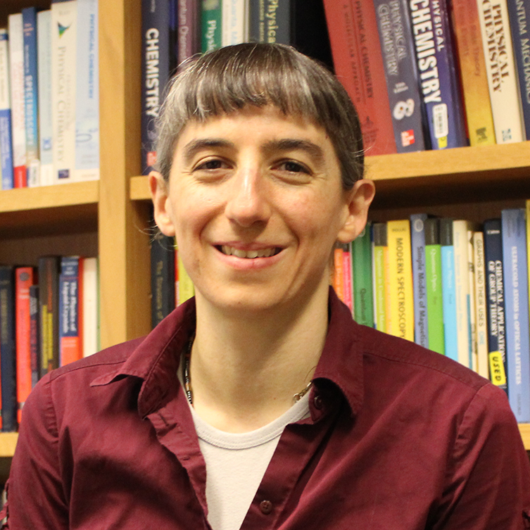 A formally dressed woman smiles for the camera.