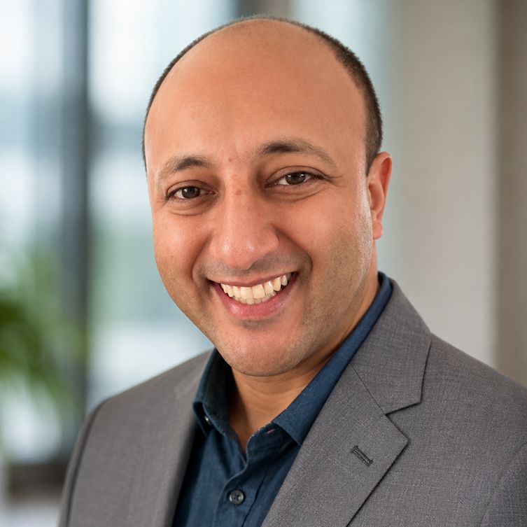 A formally dressed man smiles for the camera.