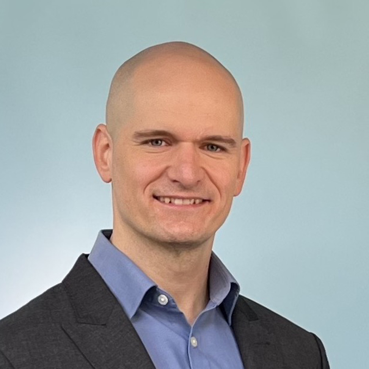 A formally dressed man smiles for the camera.