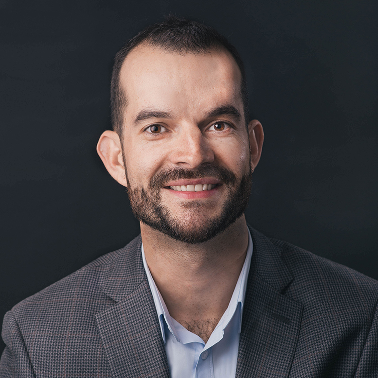A formally dressed man smiles for the camera.