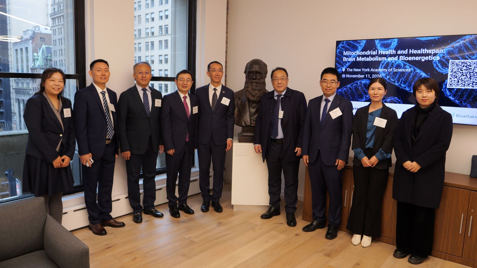 A group of people pose next to a statute.